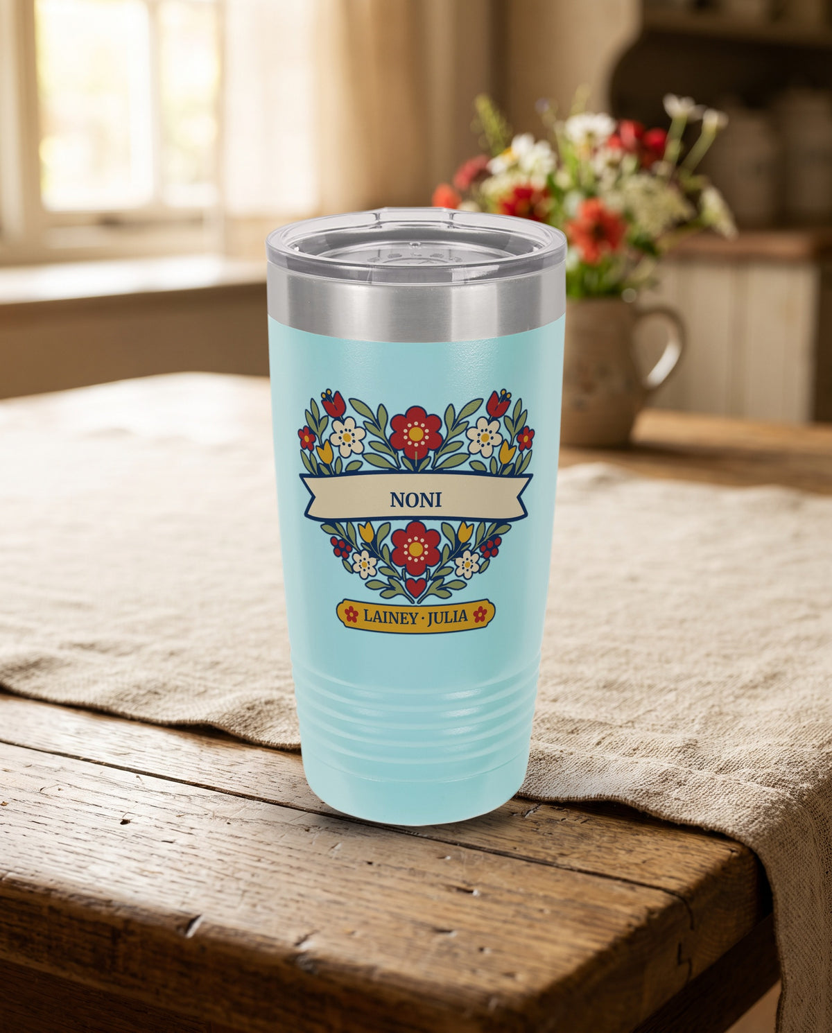 Folk Flower Heart, a folk flower heart in red, cream, gold and sage, outlined in navy, UV printed on the front of a 20oz Ringneck tumbler in Light Blue, sample name NONI