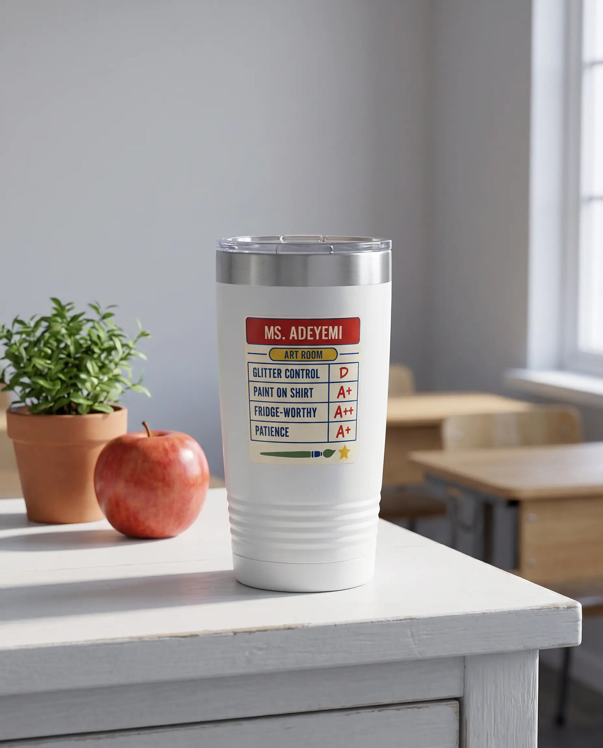 Teacher Report Card, Art Room badge on a white 20oz tumbler personalized MS. ADEYEMI, ART ROOM, a white-painted teacher's desk by a sunny classroom window