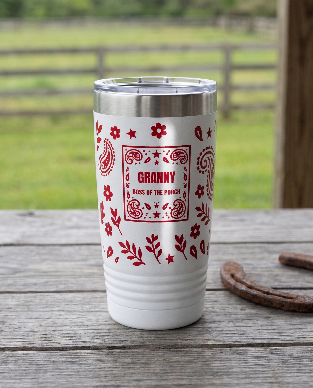 Bandana Paisley, Boss of the Porch wrap on a white 20oz tumbler personalized GRANNY, BOSS OF THE PORCH, a weathered barnwood table on a ranch porch