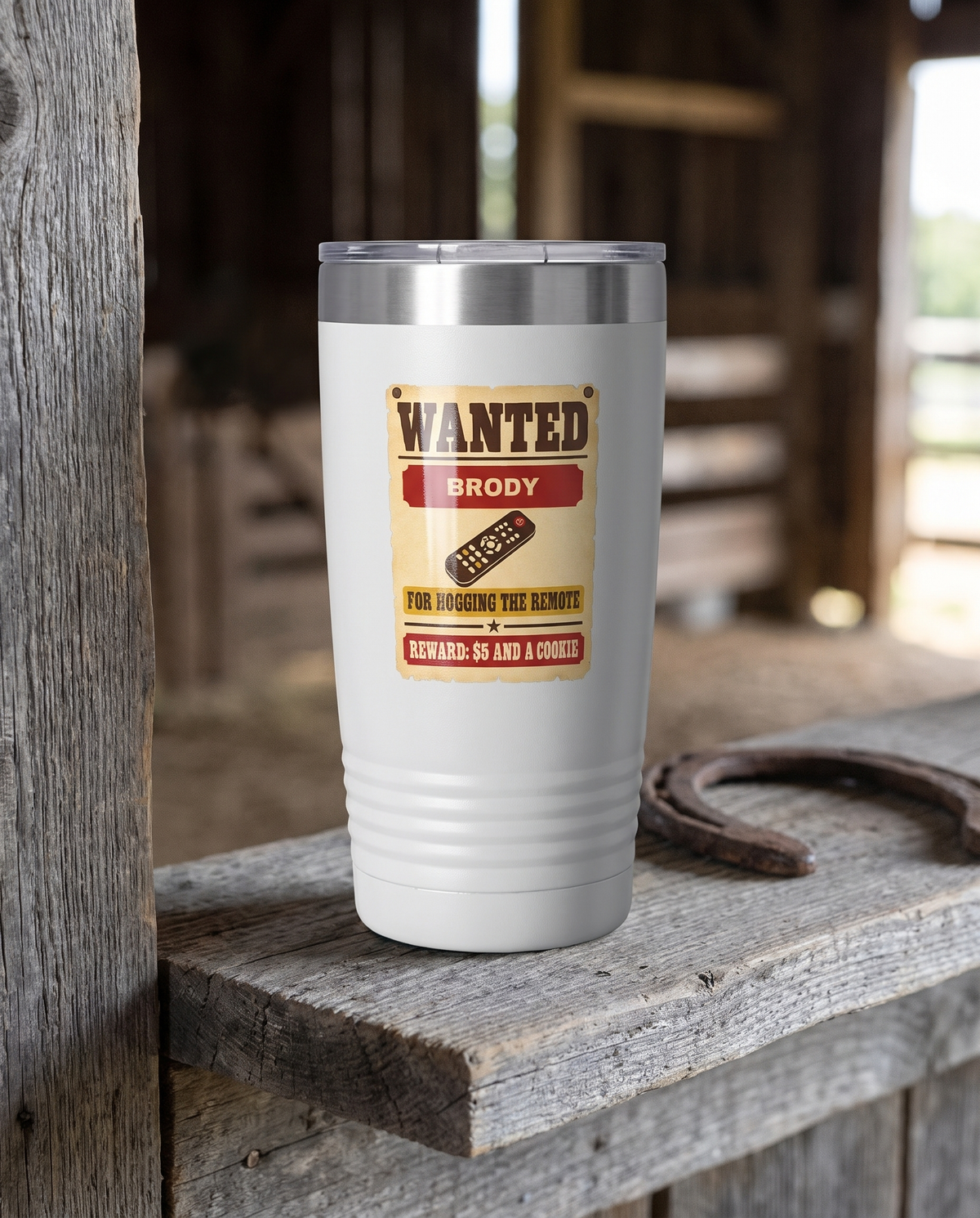 Wanted Poster, Hogging the Remote badge on a white 20oz tumbler personalized BRODY, a weathered barnwood shelf in a rustic barn