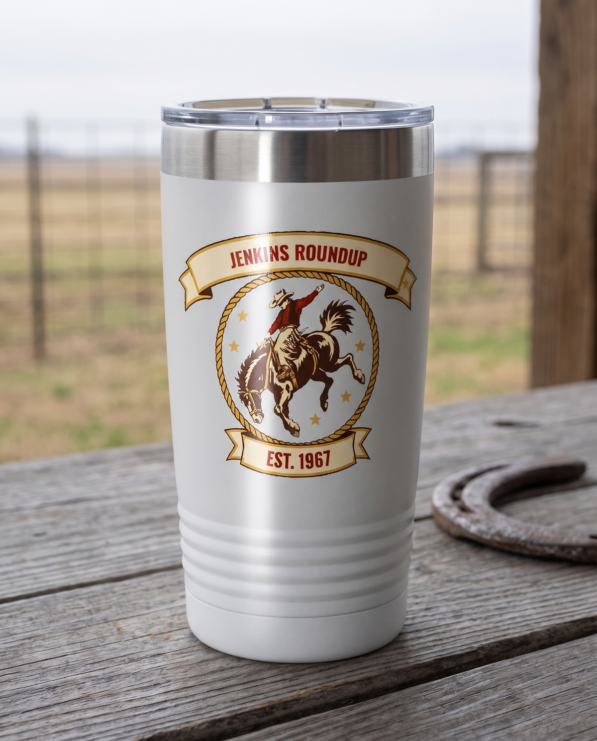 Rodeo Program, Bronc Rider badge on a white 20oz tumbler personalized JENKINS ROUNDUP, EST. 1967, a weathered barnwood table on a ranch porch