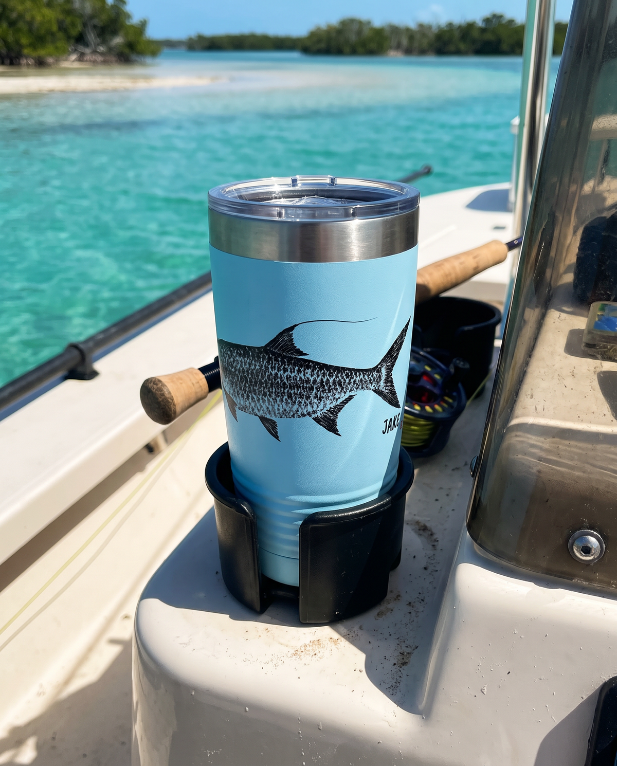 Gyotaku Tarpon personalized fishing tumbler in a boat cup holder over turquoise water