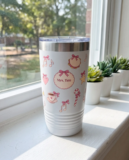 Bow Toss, Music Teacher wrap on a white 20oz tumbler personalized Mrs. Tate, three-quarter view showing the ribbed lower wall, a classroom windowsill in morning light