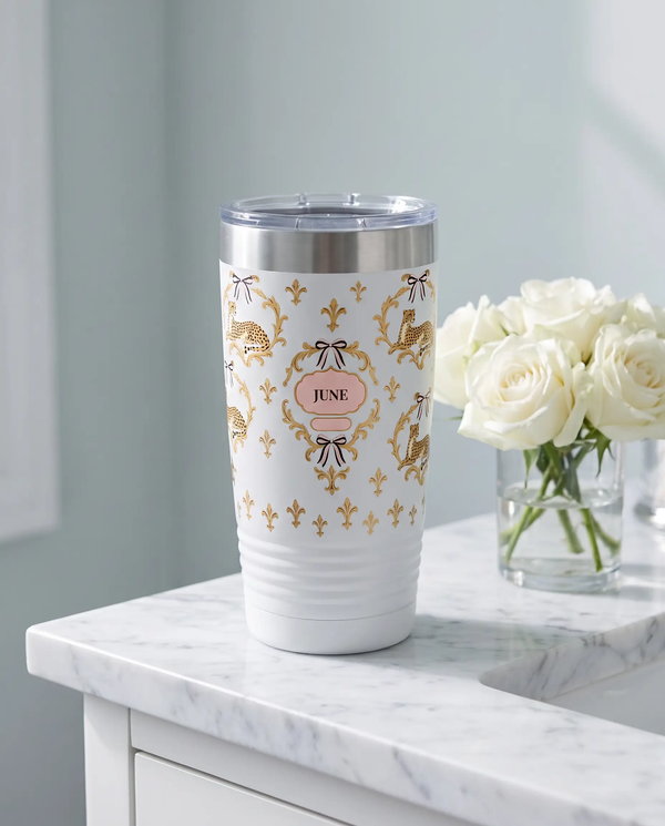 Cheetah Damask wrap on a white 20oz tumbler personalized JUNE, a marble vanity top in a softly lit dressing room