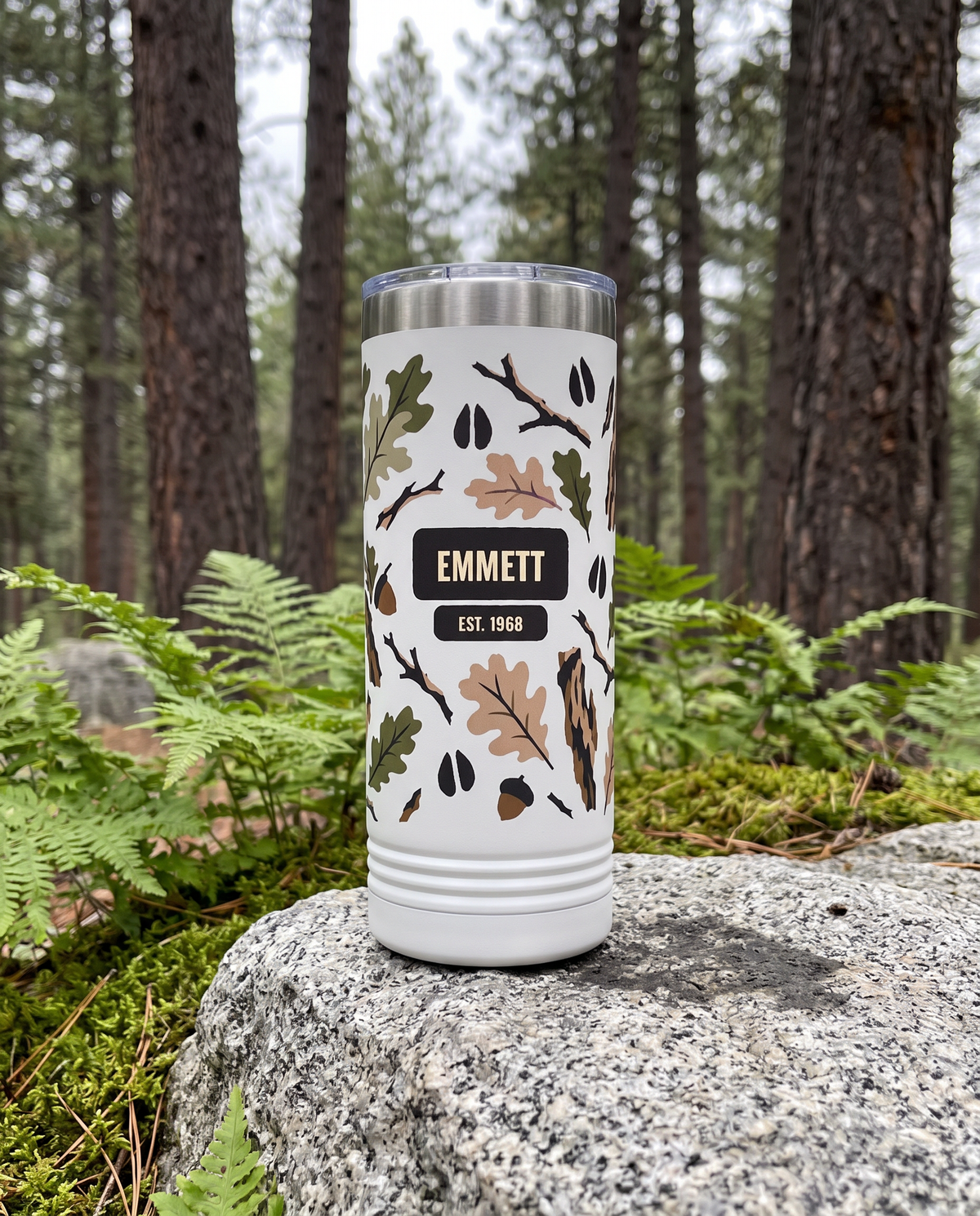 Heritage Bark Camo, Est. Year wrap on a white 22oz Skinny tumbler personalized EMMETT, EST. 1968, a granite boulder among ferns in a pine forest