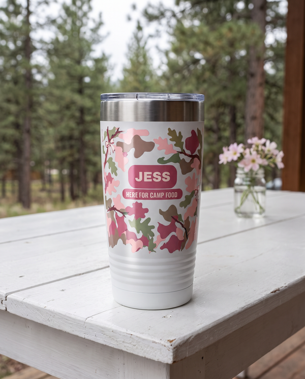 Blush Camo & Bows, Here for Camp Food wrap on a white 20oz tumbler personalized JESS, HERE FOR CAMP FOOD, a white-painted table on a cabin porch with pale pink wildflowers