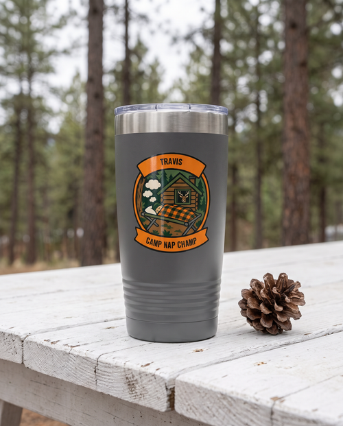 Deer Camp Patch, Camp Nap Champ badge on a gray 20oz tumbler personalized TRAVIS, CAMP NAP CHAMP, a white-painted table on a cabin porch