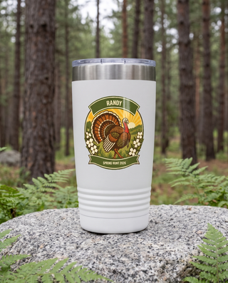 Turkey Gobbler, Spring Strut badge on a white 20oz tumbler personalized RANDY, SPRING HUNT 2026, a granite boulder among ferns in a pine forest