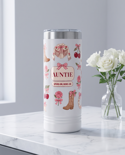 Coquette Cowgirl, Spurs On Bows On wrap on a white 22oz Skinny tumbler personalized AUNTIE, SPURS ON, BOWS ON, a white marble vanity top with a vase of white roses