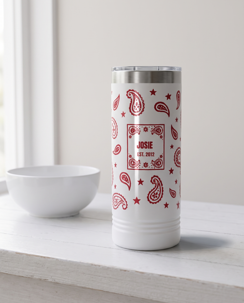 Bandana Paisley, Est. Year wrap on a white 22oz Skinny tumbler personalized JOSIE, EST. 2012, a white-painted farmhouse counter
