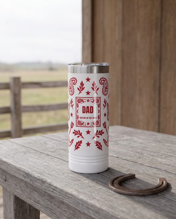 Bandana Paisley, Outlaw of the Grill wrap on a white 22oz Skinny tumbler personalized DAD, OUTLAW OF THE GRILL, a weathered barnwood table on a ranch porch