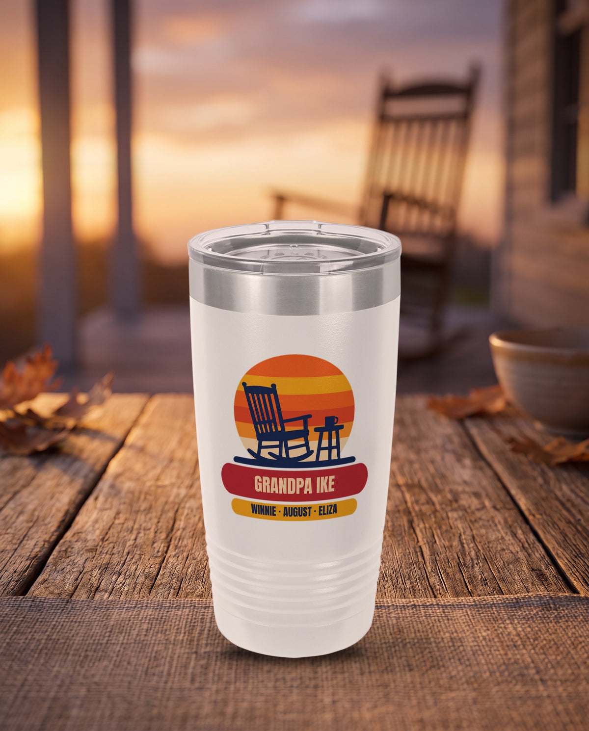 Rocking Chair Sunset, a porch sunset in navy, orange, gold and red, UV printed on the front of a 20oz Ringneck tumbler in White, sample name GRANDPA IKE