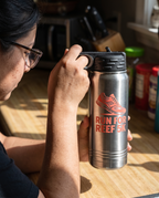 20oz Water Bottle, UV printed with a sample business logo (illustrative image, in hand for scale)