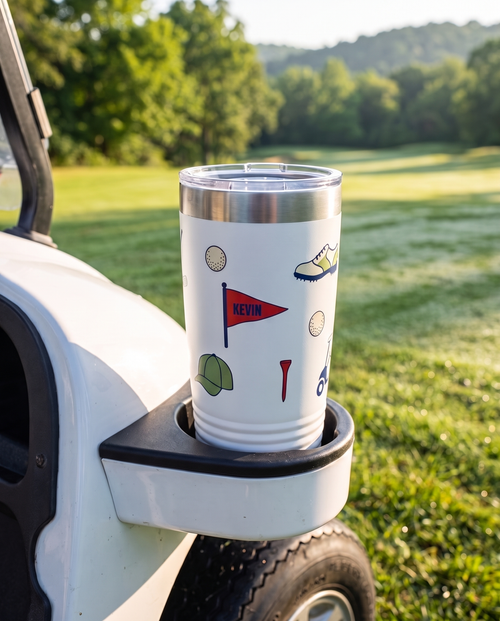 Bag Drop Pennant personalized golf tumbler in a golf cart cup holder beside the fairway, name KEVIN
