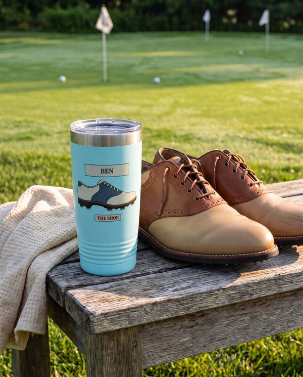 Course Plate Shoe personalized golf tumbler in light blue on a bench beside saddle golf shoes, name BEN