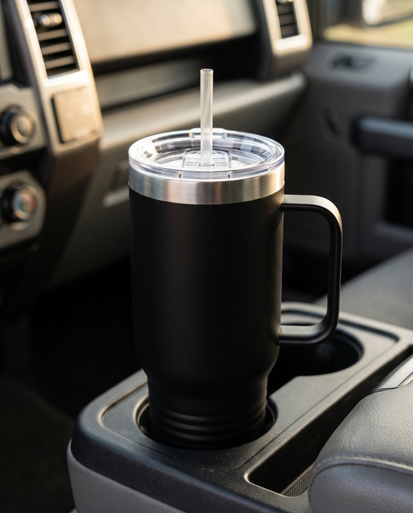 Clear straw through the lid of a black 40oz travel mug in a truck cup holder