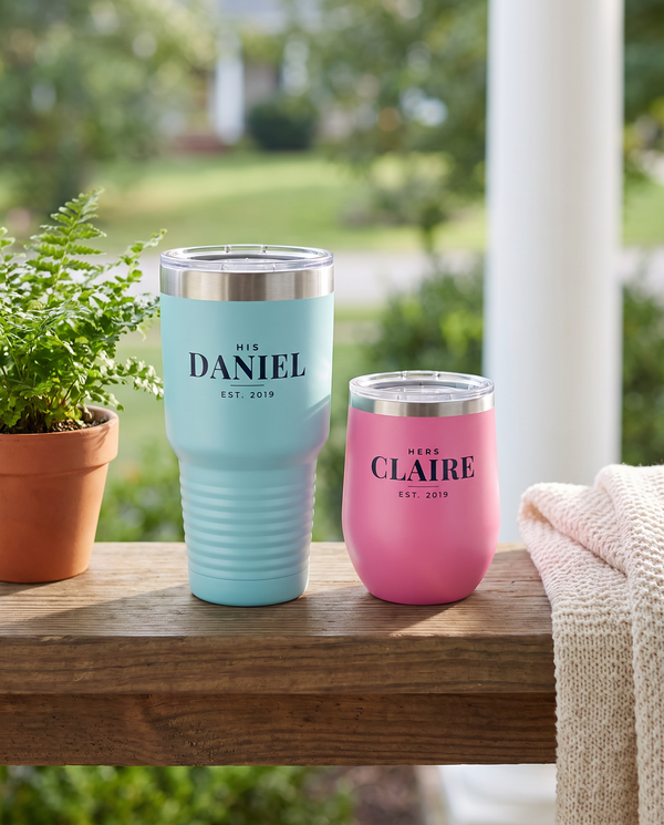 His and hers set: light blue 30oz tumbler named Daniel and pink wine tumbler named Claire on a porch railing