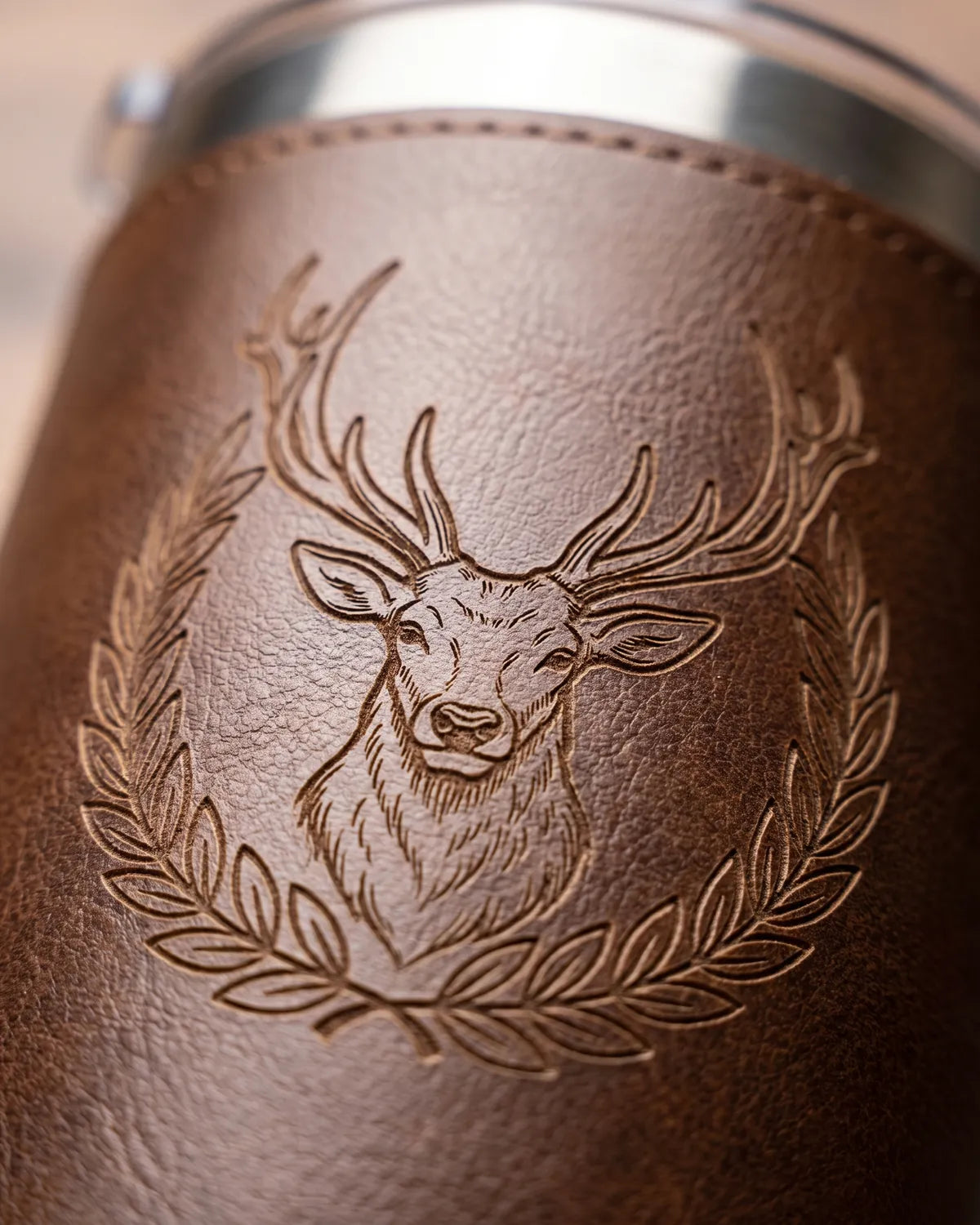 Close-up of an engraved deer on a leatherette tumbler